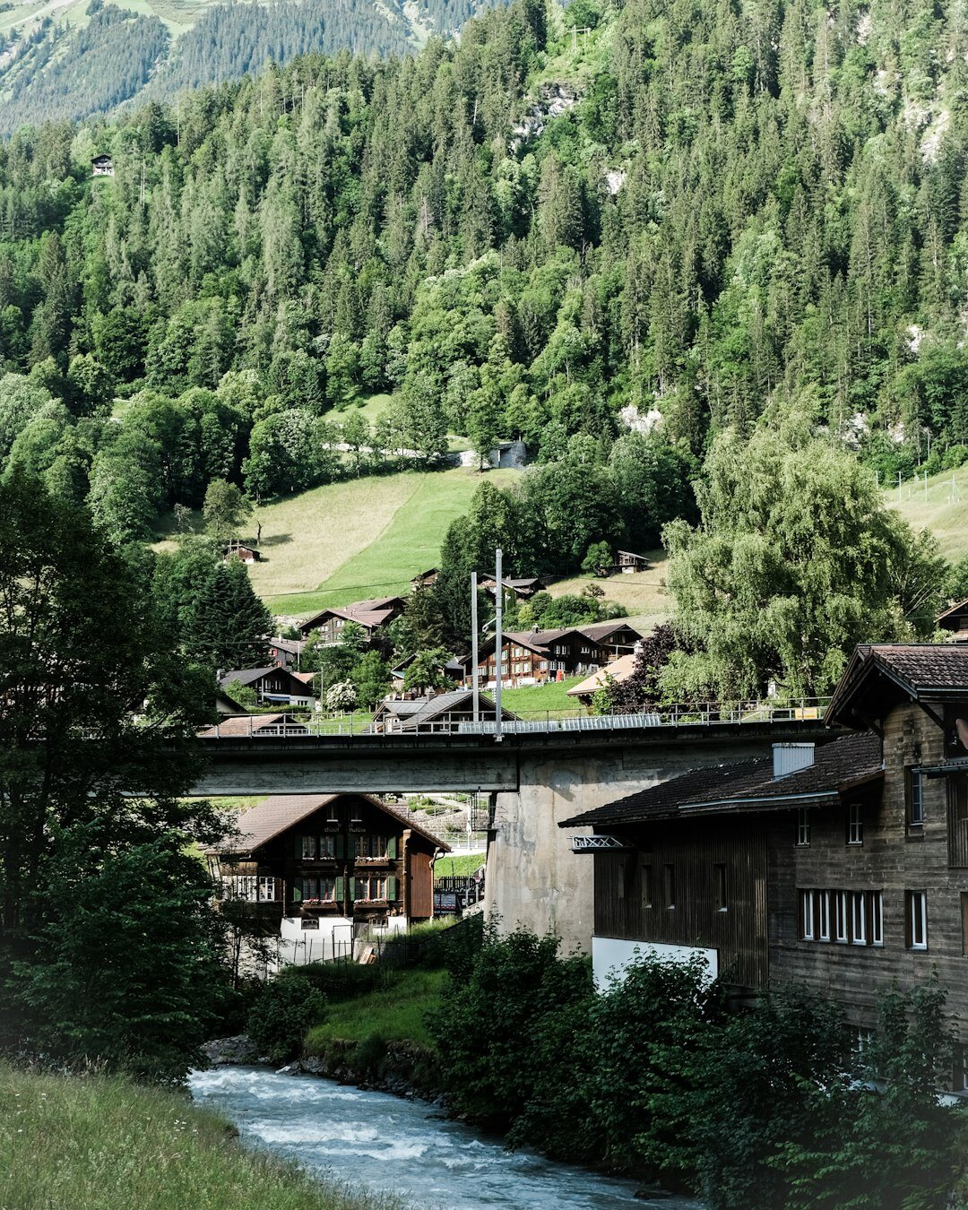 Alpine river flowing through a Swiss valley near industrial infrastructure